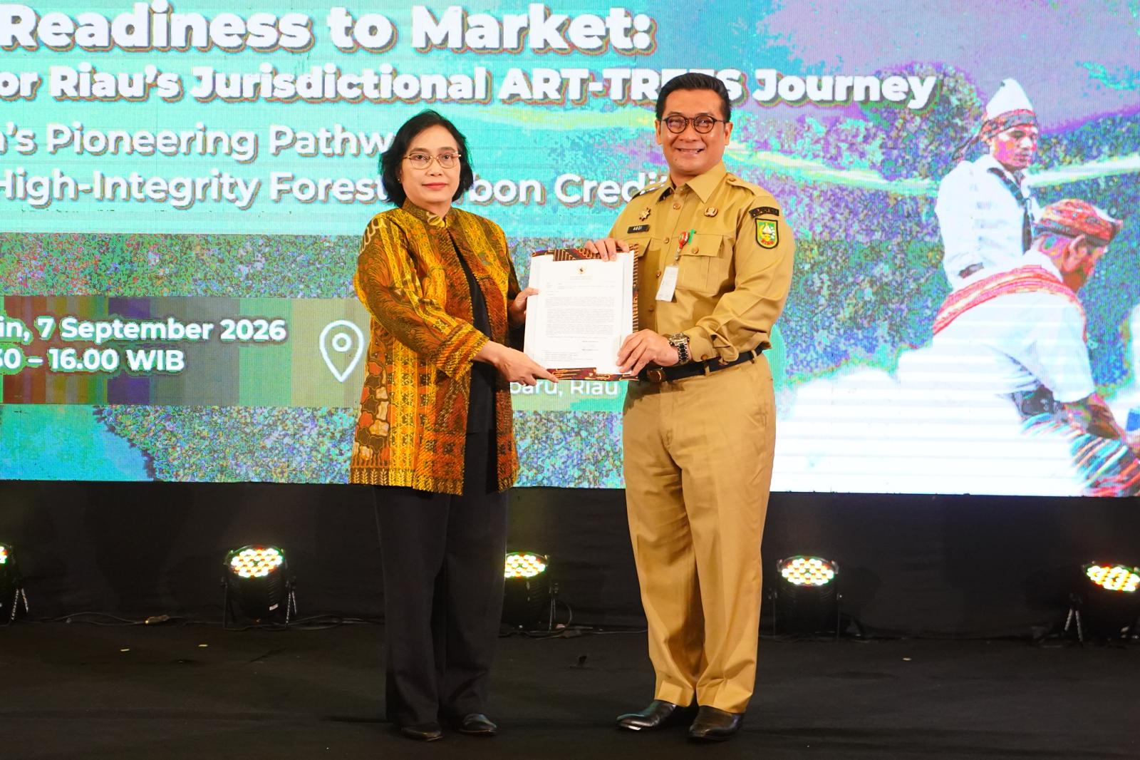 Two officials display the Ministry of Forestry endorsement at the GREEN for Riau meeting.